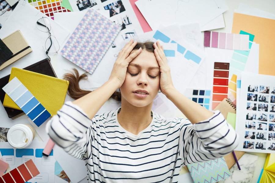 Woman holding her head while feeling overwhelmed by daily stress